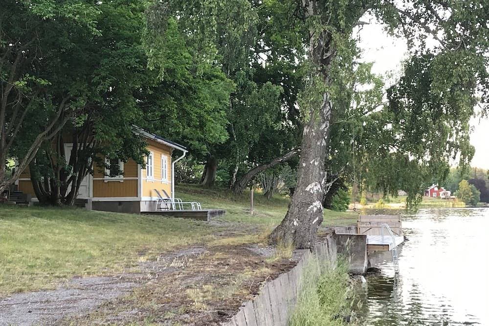 Foto 7 von 20: Cottage mit sonnigem Holzdeck am Wasser.