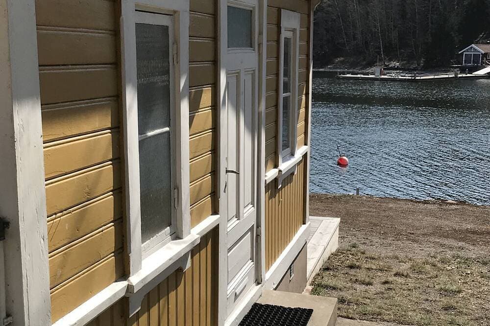 Foto 6 von 20: Cottage mit sonnigem Holzdeck am Wasser.