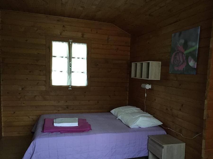 Foto 10 von 44: Les Chalets De Fiolles - Chalet 4 personen - Chalet Pmr Confort - 1 Schlafzimmer - Klimaanlage - TV - BBQ - Reinigung* - 35m2 + überdachte Terrasse von 14m2