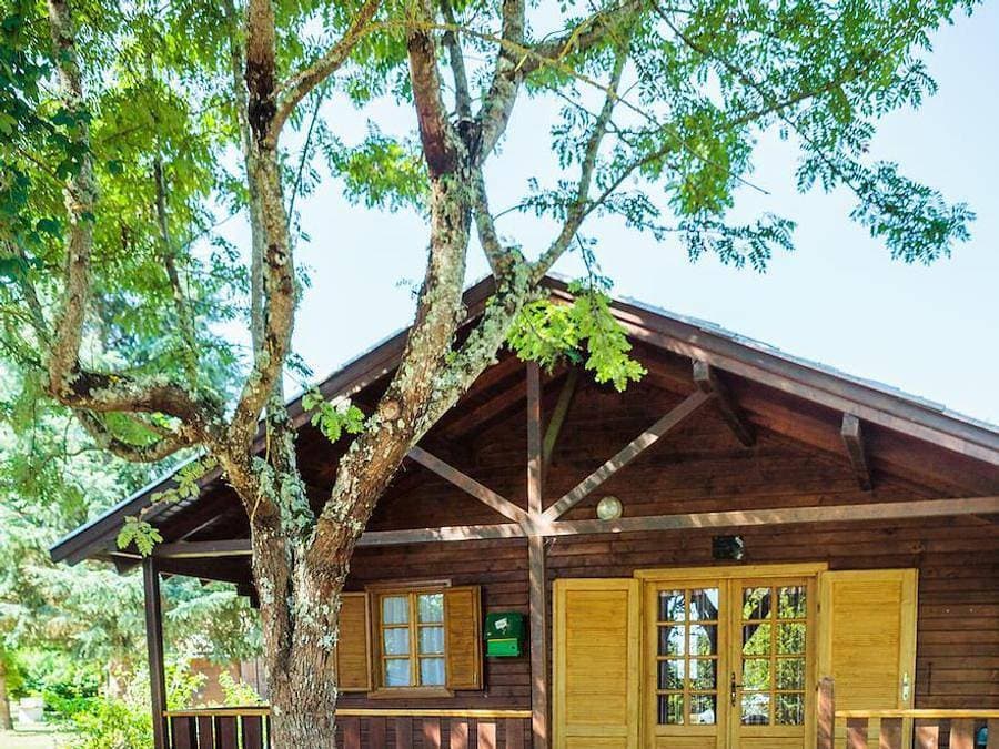 Foto 3 von 44: Les Chalets De Fiolles - Chalet 4 personen - Chalet Pmr Confort - 1 Schlafzimmer - Klimaanlage - TV - BBQ - Reinigung* - 35m2 + überdachte Terrasse von 14m2